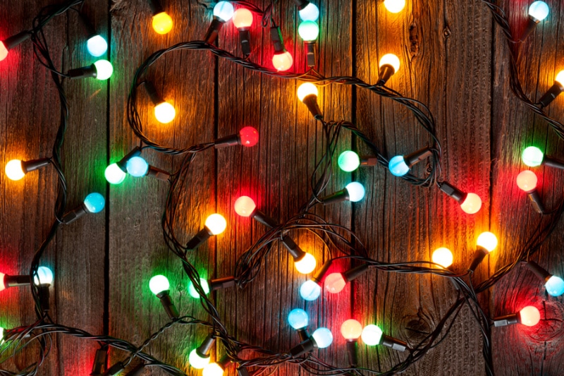 Holiday Safety Tips. Christmas colorful lights on wooden table.