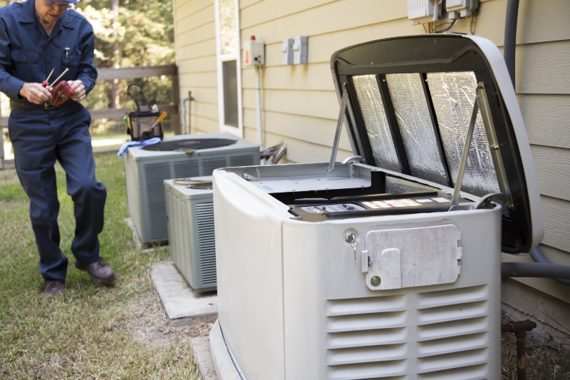 Maintaining Your Whole-House Generator - Senior Adult air conditioner Technician/Electrician services outdoor AC unit and the Gas Generator.