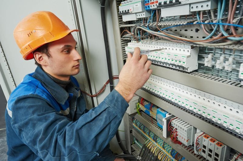 Image of technician working with electrical. Electrical Inspections Versus Tune-Ups.